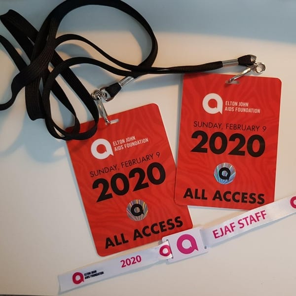 Two red Elton John AIDS Foundation "All Access" passes and an "EJAF STAFF" wristband.