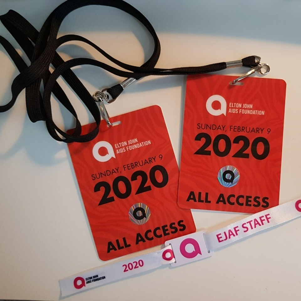 Two red Elton John AIDS Foundation "All Access" passes and an "EJAF STAFF" wristband.